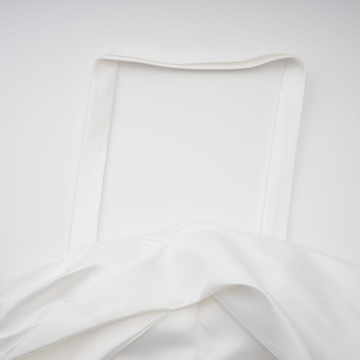 A white halterneck mini dress with ruffled details worn by a model named Olivia featuring a sleeveless design and a short hemline