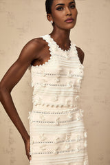 A white knit matching set consisting of a top and skirt with pointelle trim details The top features a sleeveless design while the skirt has a fitted silhouette Both pieces showcase delicate pointelle pattern along the edges