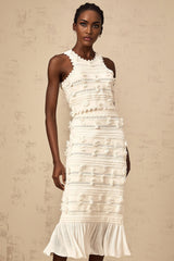 A white knit matching set featuring a top and skirt with pointelle trim detailing The top is sleeveless with a scoop neck while the skirt is fitted and knee length Both pieces have a delicate textured pattern throughout
