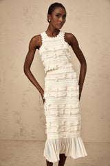 A white knit twopiece outfit consisting of a top and skirt with delicate pointelle trim detailing The set features a matching design and is named Paola