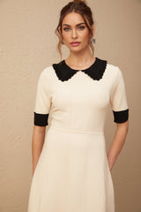 A white knitted mini dress with a split hem featuring a fitted silhouette and short sleeves named Andrea