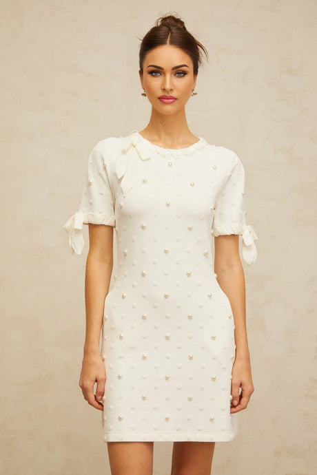 A white knitted mini dress with polka dot pattern and heart designs featuring the Prunelle brand
