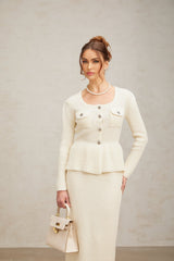 A white knitted twopiece outfit consisting of a top and skirt set named Manon The top is sleeveless with a cropped style while the skirt has a fitted waist and falls to midi length Both pieces feature a textured knit pattern creating a cohesive and stylish matching set