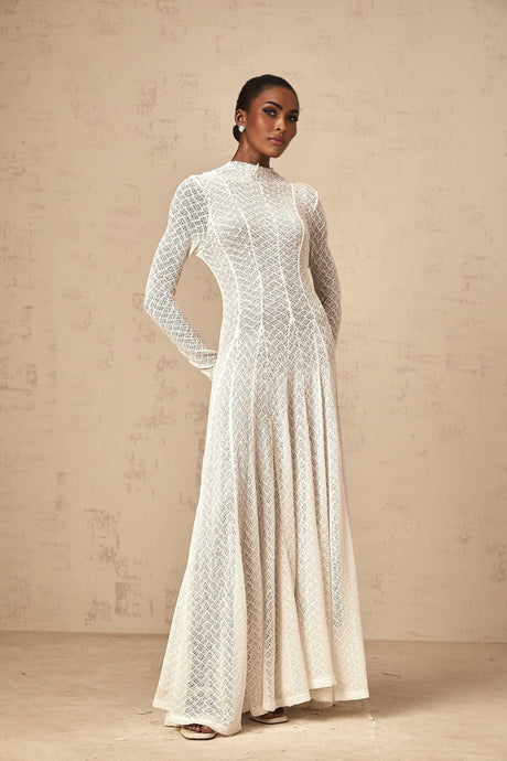 A white lace maxi dress with a wavy pattern design and long flowing silhouette