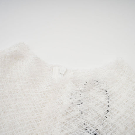 A white lace maxi dress with a wavy pattern featuring long sleeves and a floor length skirt