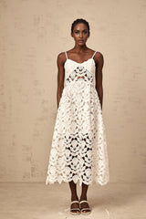 A white lace midi dress with cutout details featuring a delicate floral pattern and fitted silhouette