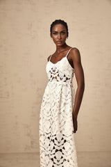 A white lace midi dress with cutout details named Delphine featuring a fitted silhouette and intricate floral lace pattern