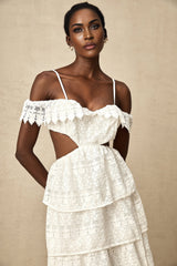 A white lace midi dress with openwork design and delicate floral patterns worn by a model standing against a plain background