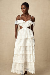 A white lace midi dress with openwork detailing named Genevieve featuring a delicate feminine design with a flowy silhouette and intricate lace patterns