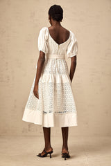 A white lace midi dress with tiered skirt and corded lace detailing named Helene