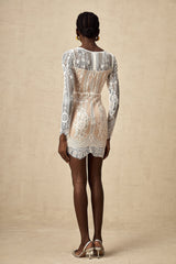 A white lace mini dress with scalloped hem details and delicate floral pattern