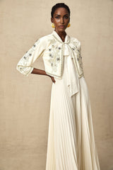 A white matching set consisting of an embellished pleated jacket paired with a dress both in a crisp white color