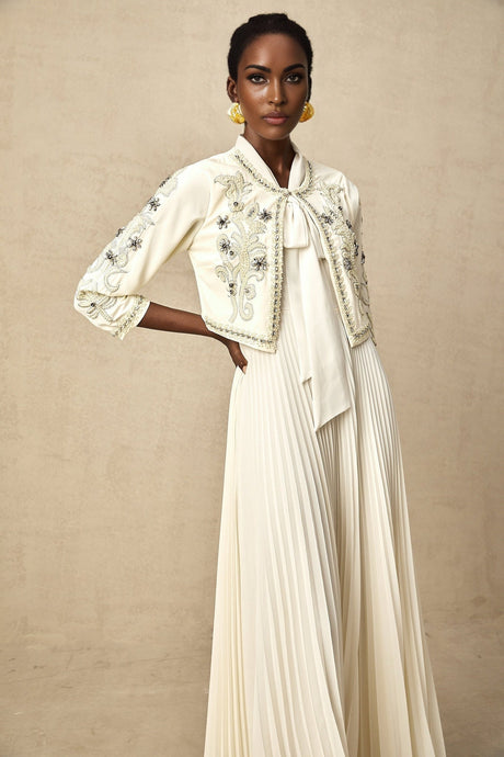 A white matching set consisting of an embellished pleated jacket paired with a dress both in a crisp white color