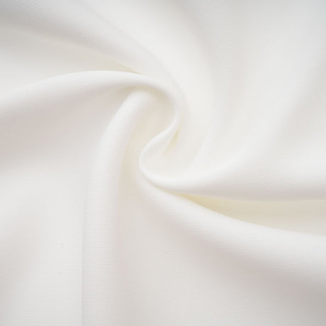 A white matching set featuring a creased top and trousers worn by a model against a plain background