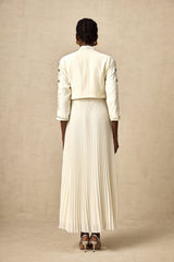 A white matching set featuring a pleated jacket and dress with embellished details The jacket has a structured silhouette while the dress is fitted Both pieces are adorned with delicate embellishments for an elegant look