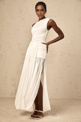 A white maxi dress with a single shoulder strap and shirred panel detailing featuring a long flowing skirt and fitted bodice