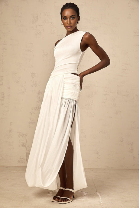 A white maxi dress with a single shoulder strap and shirred panel detailing featuring a long flowing skirt and fitted bodice