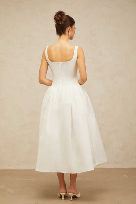 A white midi dress with a bowknot detail and flounce design featuring a fitted bodice and flowing skirt