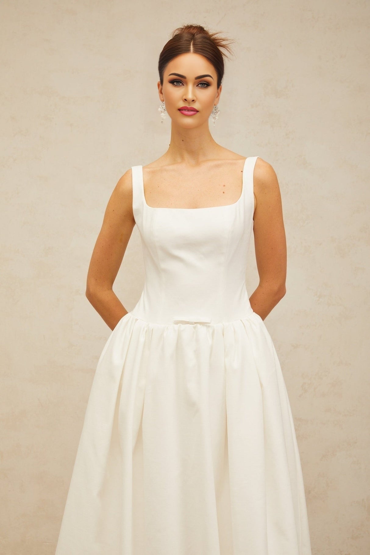 A white midi dress with a bowknot detail and flounce design named Perrine