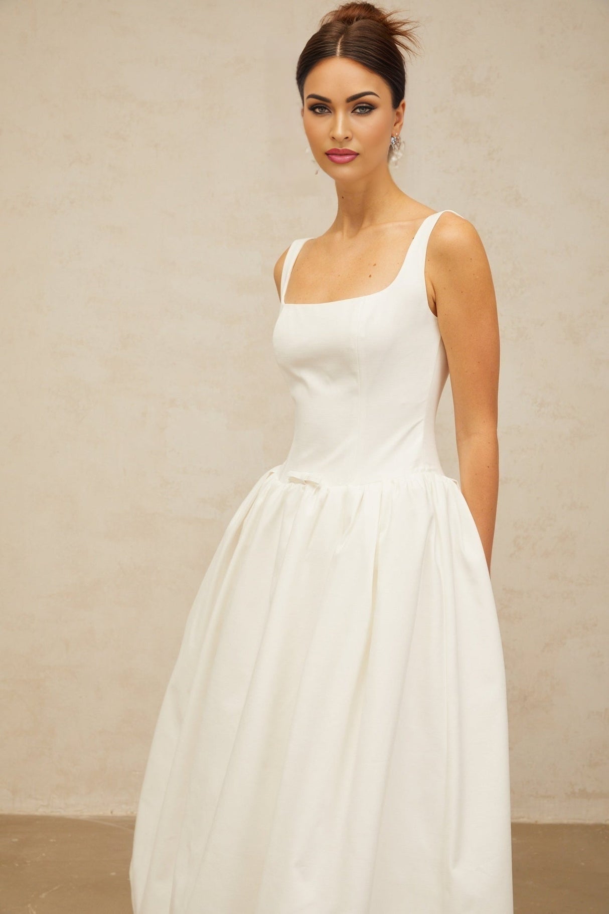 A white midi dress with a bowknot detail and flounced design named Perrine