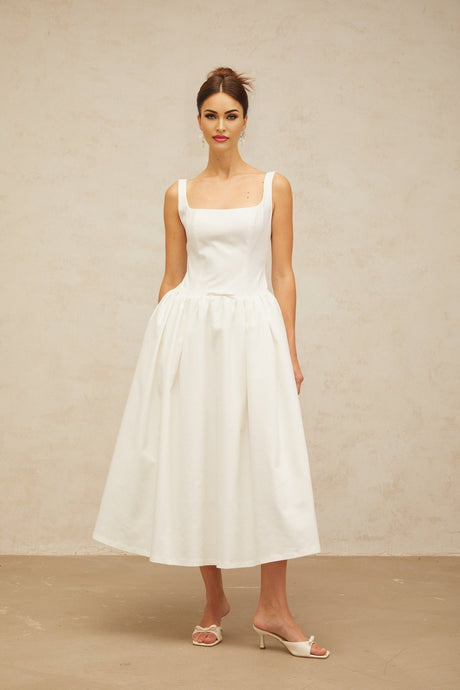 A white midi dress with a bowknot detail and flounced hemline featuring a feminine and elegant design