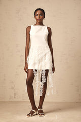 A white midi dress with a discshaped design pattern and fringe details worn by a model named Justine