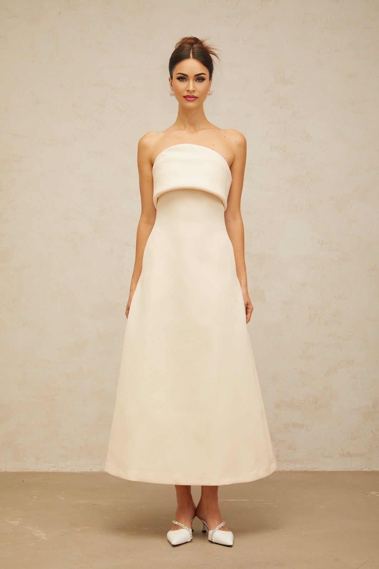 A white midi dress with a folded corset bodice and a fitted silhouette named Raphaelle
