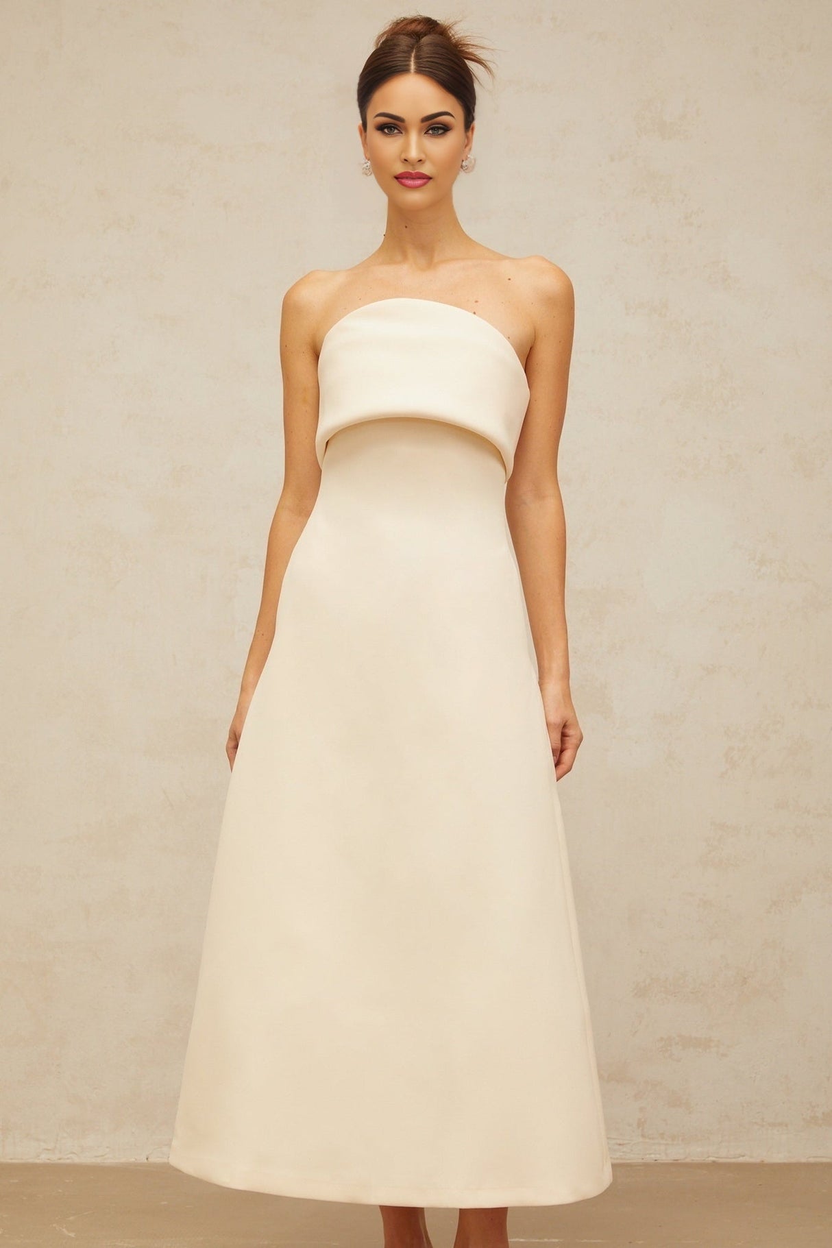 A white midi dress with a folded corset bodice and slim silhouette featuring a design by Raphaelle