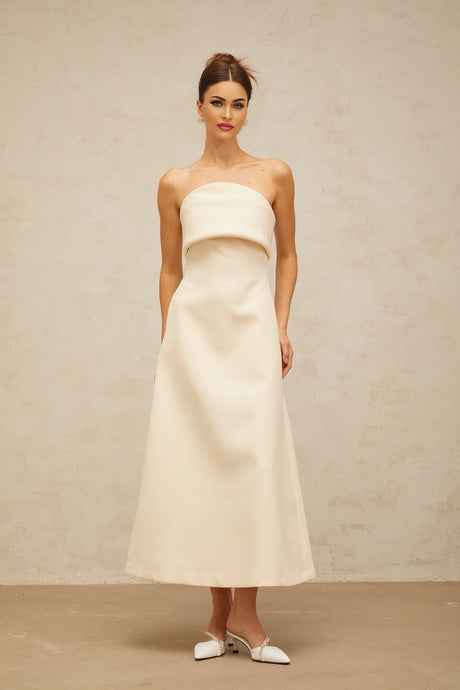 A white midi dress with a folded corset style bodice and a fitted silhouette named Raphaelle