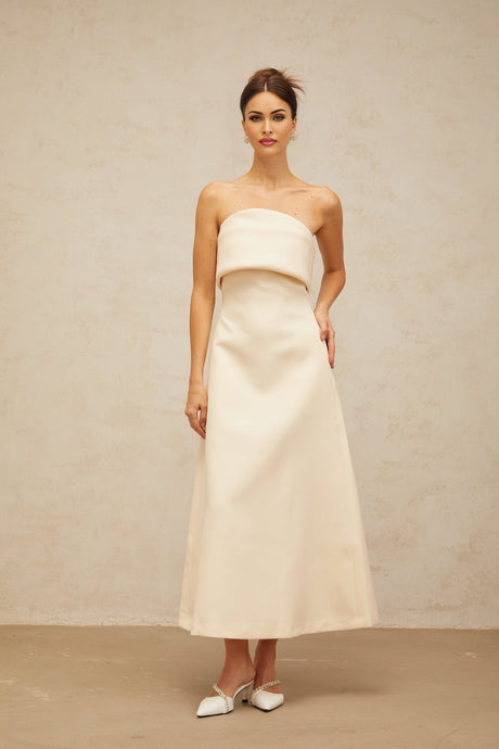 A white midi dress with a folded corset style bodice featuring a fitted silhouette and sleeveless design named Raphaelle