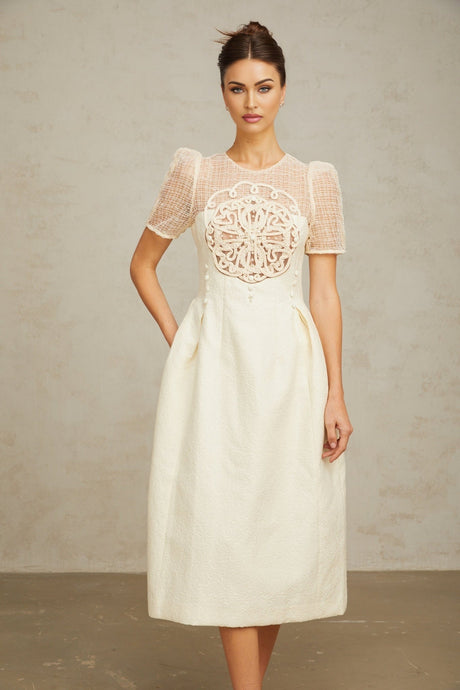 A white midi dress with braided panel details and a fitted silhouette on a female model