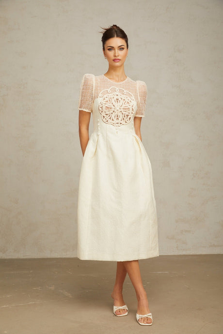 A white midi dress with braided panel details and a fitted silhouette on a female model