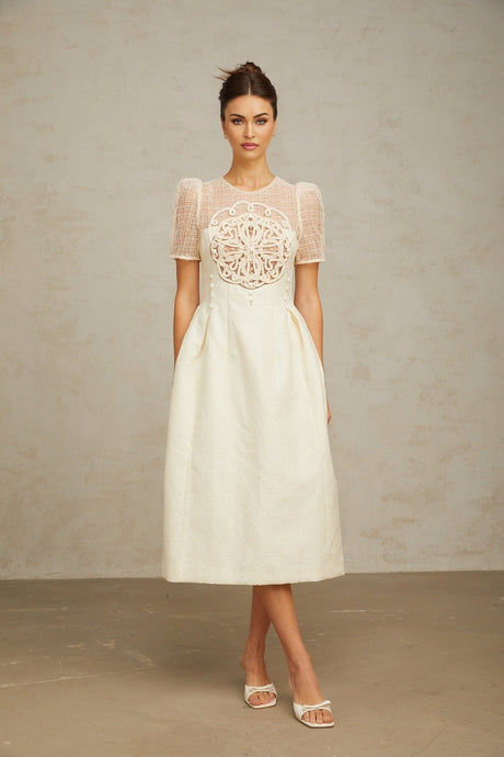 A white midi dress with braided panelling and a fitted silhouette