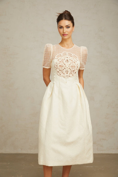 A white midi dress with braided panelling details and a fitted silhouette named Camille