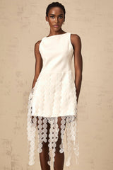 A white midi dress with circular disc design and fringe details worn by a model named Justine