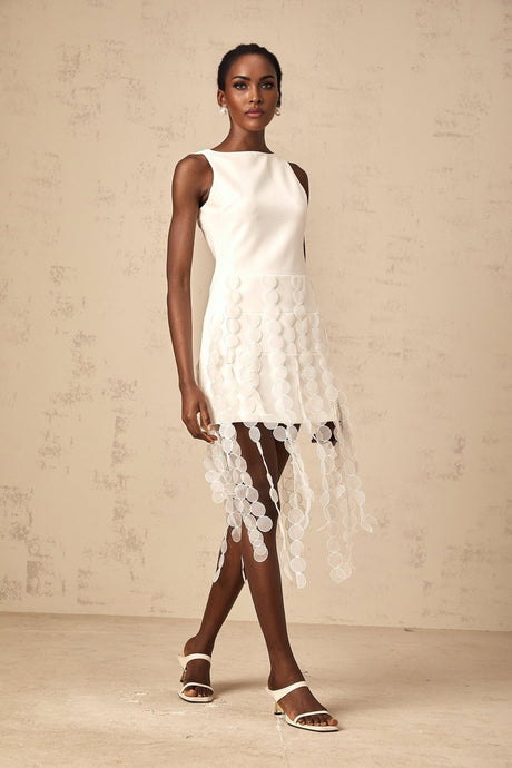 A white midi dress with circular disc designs and fringe details named Justine
