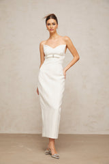 A white midi dress with corsetstyle bodice and bow detail featuring a fitted silhouette and feminine design