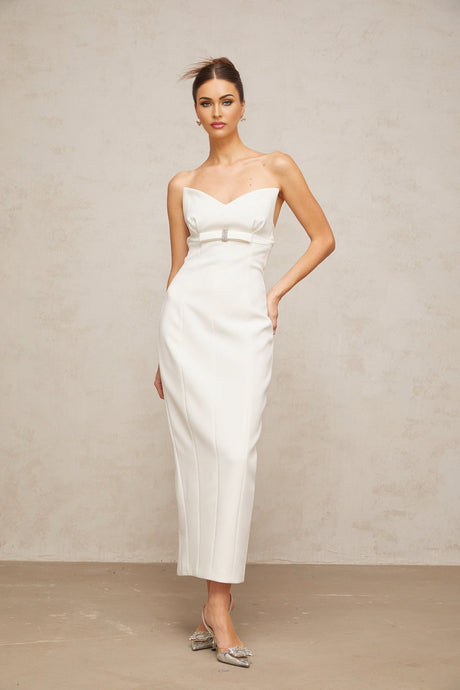 A white midi dress with corsetstyle bodice and bow detail featuring a fitted silhouette and feminine design