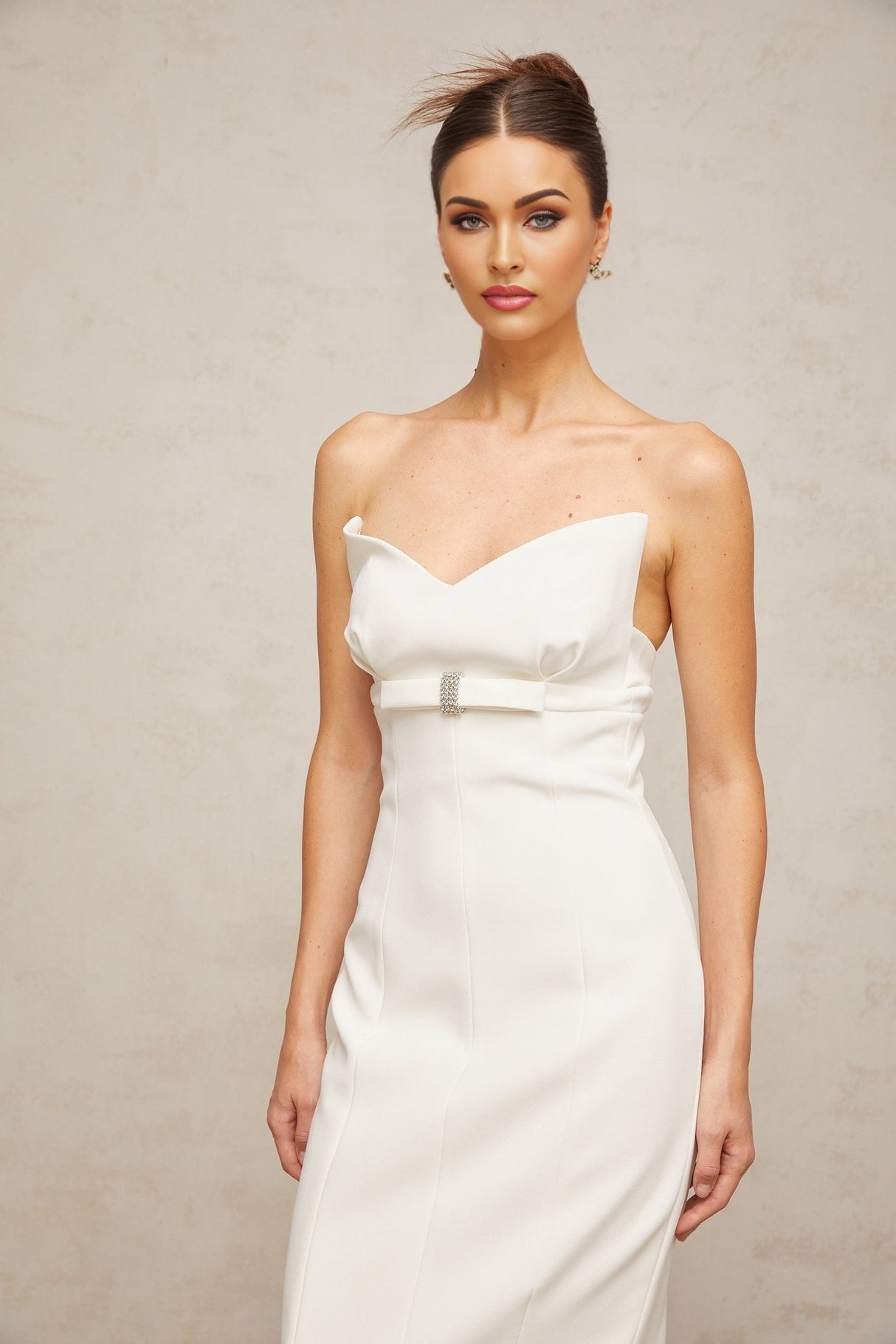 A white midi dress with corsetstyle bodice and bow detail named Isaline