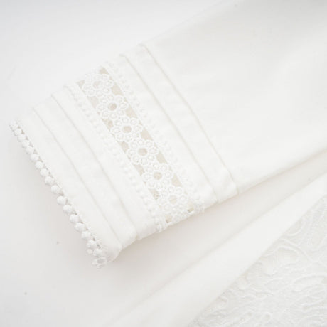 A white midi dress with embroidered panelling details named Madeleine featuring a fitted silhouette and delicate floral embroidery throughout the bodice and skirt