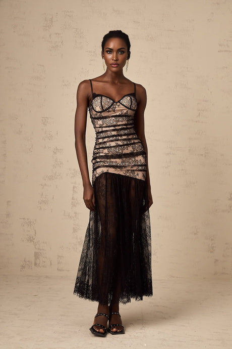 A white midi dress with floral embroidery and lace details featuring a bustier top and ruffled accents