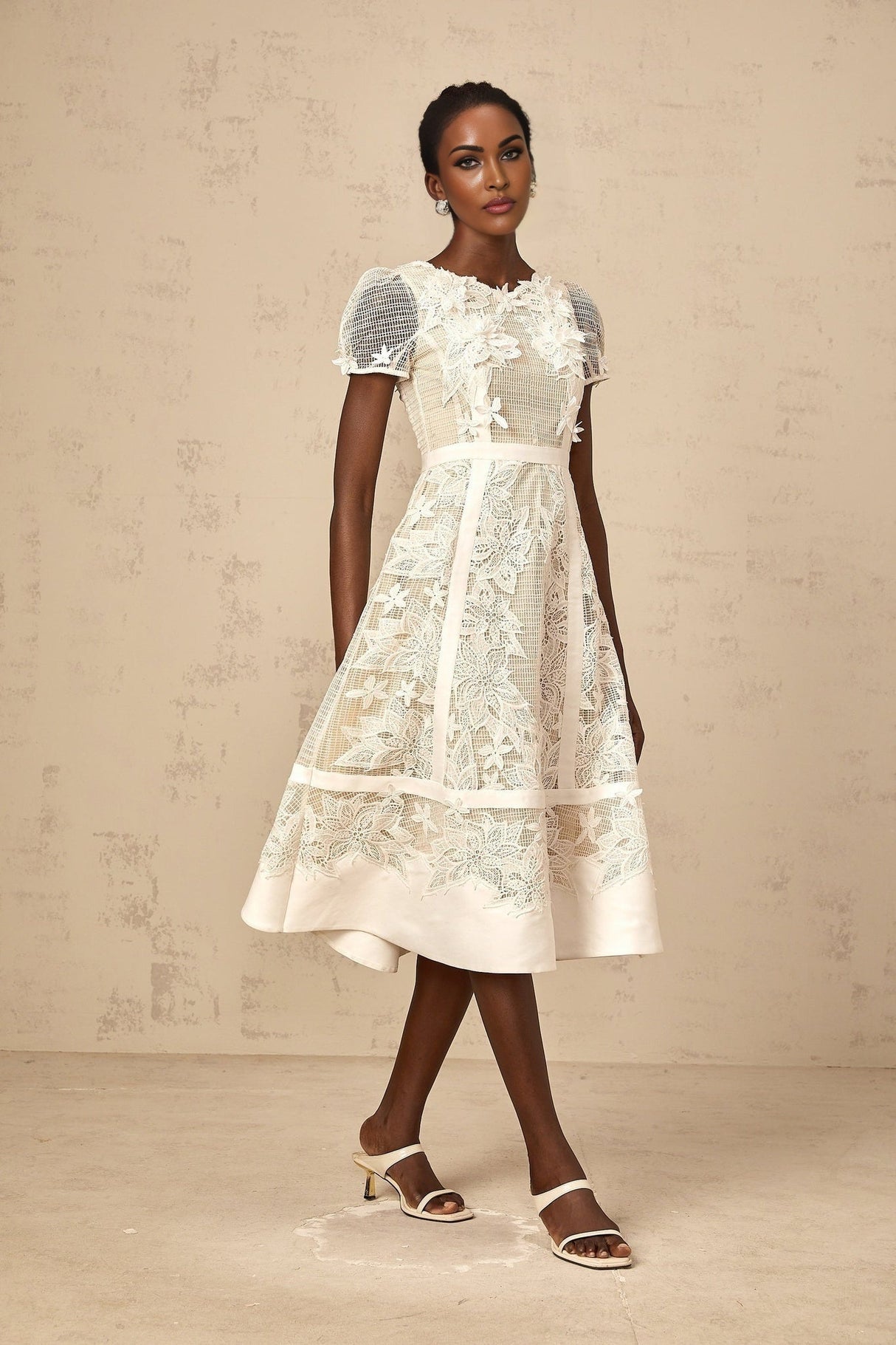 A white midi dress with floral embroidery featuring a feminine silhouette and delicate flower patterns adorning the fabric