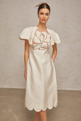 A white midi dress with floral jacquard pattern featuring a fitted bodice and flared skirt