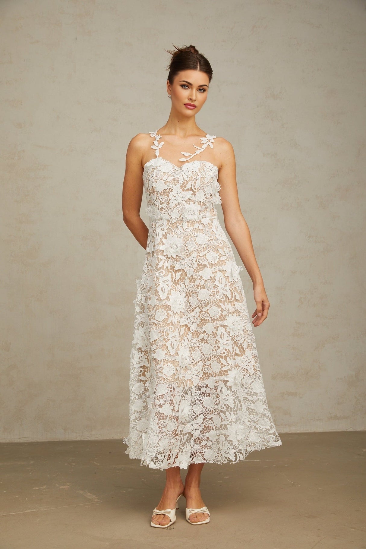 A white midi dress with lace detailing and tulle panels featuring a delicate and feminine design
