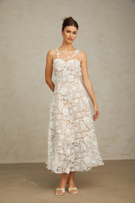 A white midi dress with lace detailing and tulle panels featuring a delicate and feminine design