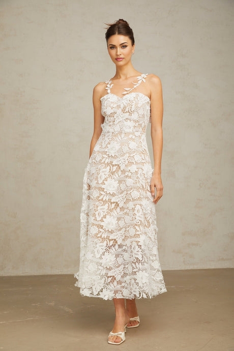 A white midi dress with lace detailing and tulle panels featuring a feminine silhouette and delicate design elements