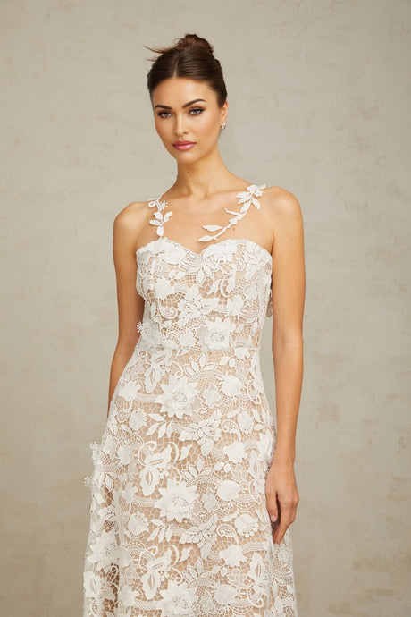 A white midi dress with lace detailing and tulle panels featuring a feminine silhouette and delicate floral patterns
