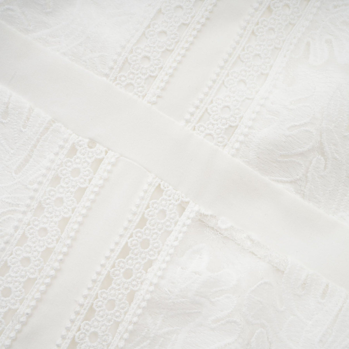 A white midi dress with panelled design and embroidery details named Madeleine featuring a feminine silhouette and delicate pattern work