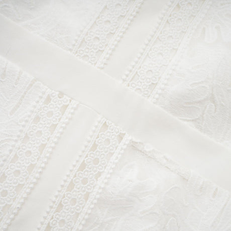 A white midi dress with panelled design and embroidery details named Madeleine featuring a feminine silhouette and delicate pattern work