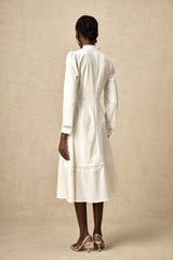 A white midi dress with panelled design and embroidery details named Madeleine featuring a feminine silhouette and delicate stitching throughout